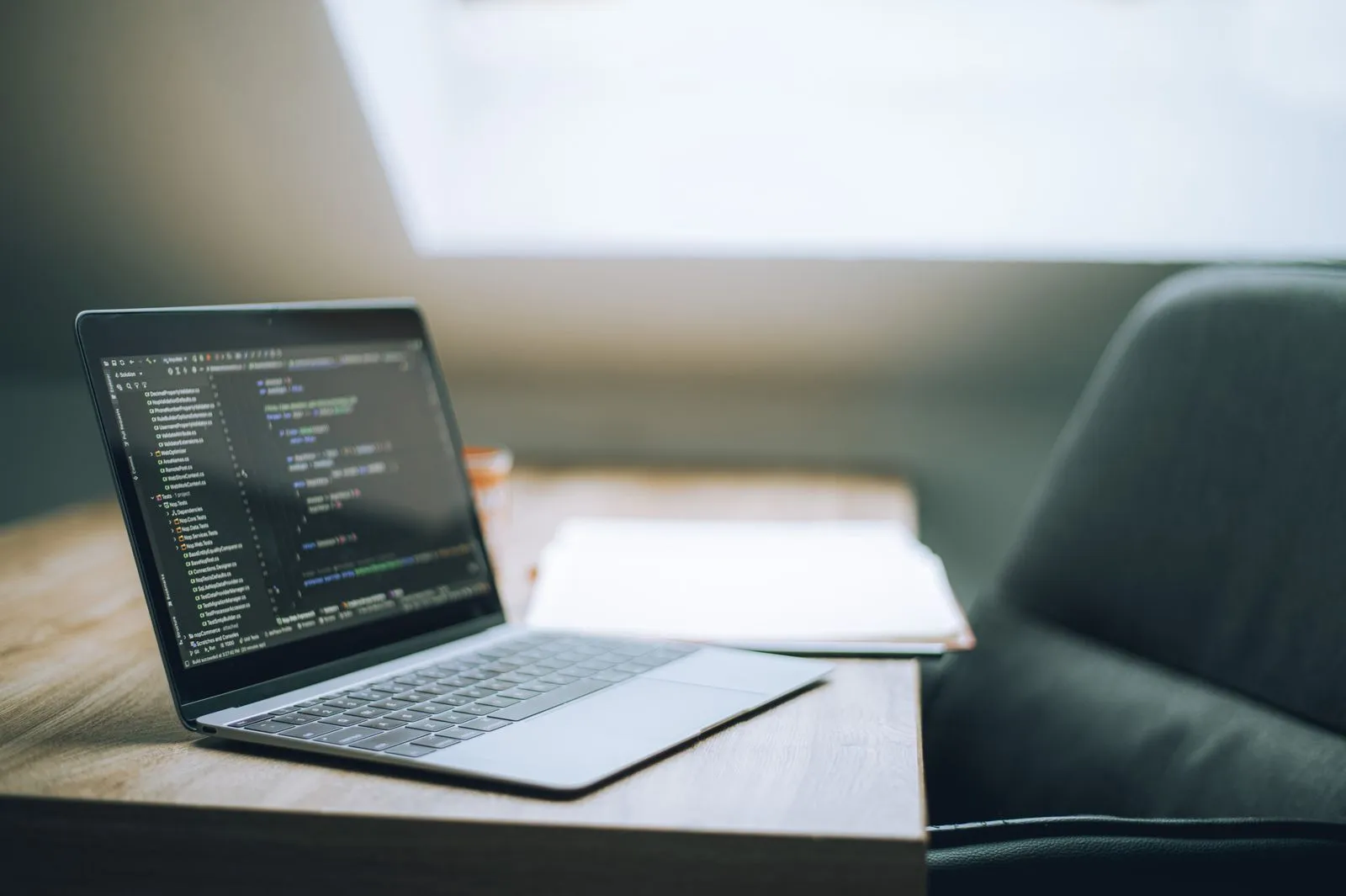 A laptop displaying code on a desk.