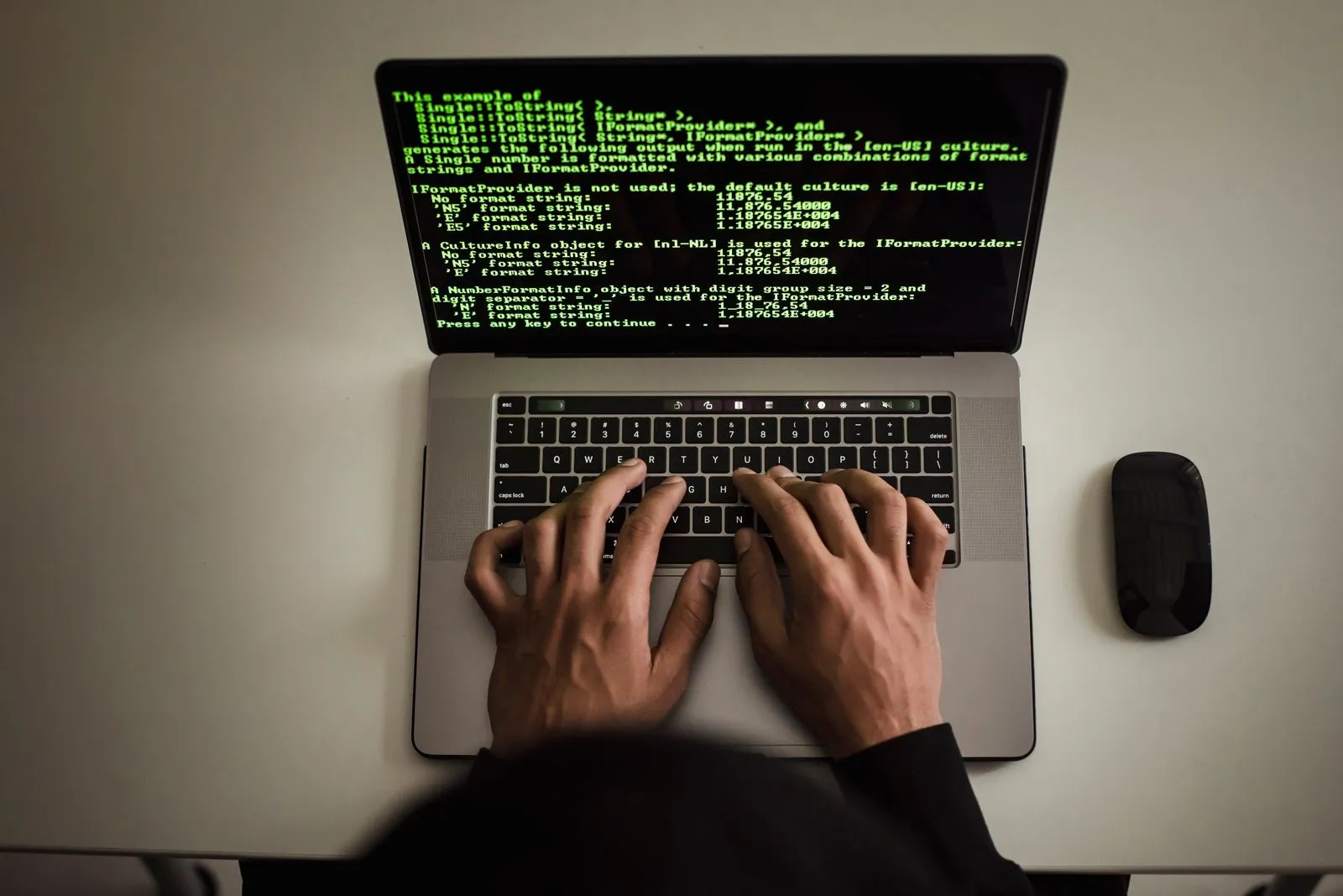 Hands at a laptop displaying terminal output.