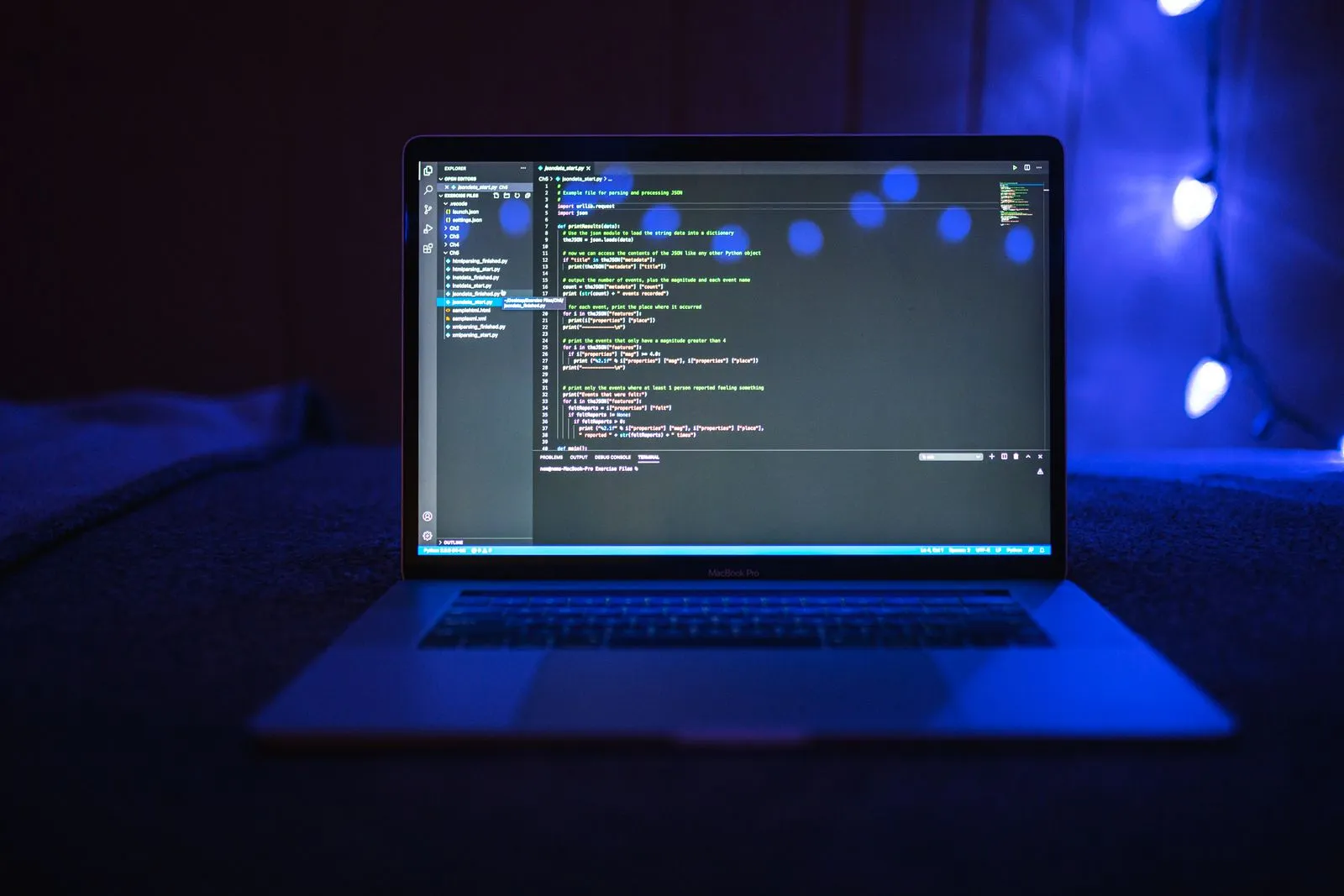 Visual Studio Code open on a blue-lit laptop.
